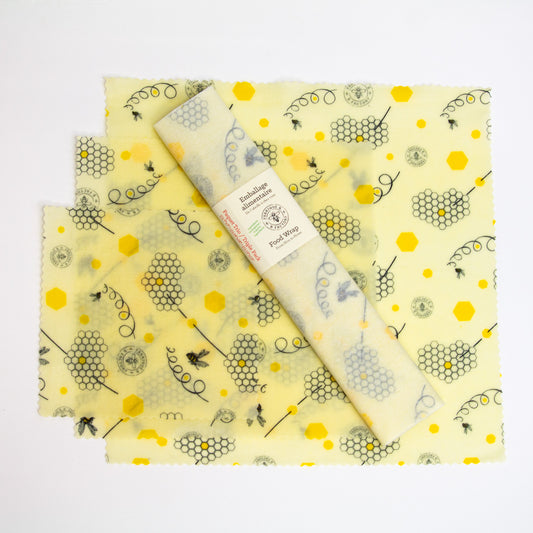 Trio pack of beeswax food wraps set  upon one small, one medium, one large beeswax food wrap with honeycomb and bee pattern with B Factory logo