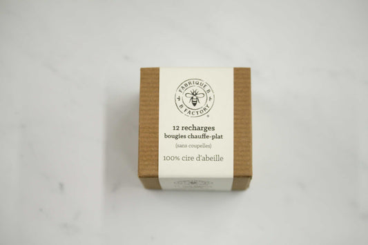 Carboard box filled with 12 beeswax tea light candle refills by B Factory