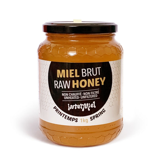 a 1kg jar of raw spring harvest honey by Intermiel on a white background