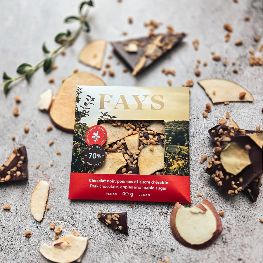 Fays chocolate bar packaging with dark chocolate pieces and maple sugar and apple slices on a gray surface