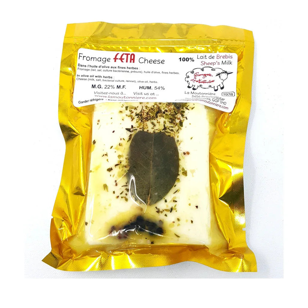 La Moutonnière feta with herbs and olive oil, featuring creamy feta cubes marinated with herbs in oil.