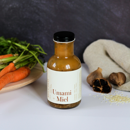 Bottle of Umami Miel sauce with vegetables on a gray background