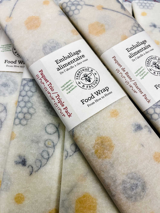 Reusable beeswax wraps with honeycomb pattern rolled up in cardboard ring packaging with B Factory logo