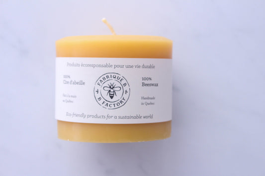 Handmade beeswax candle wrapped in cardboard ring packaging with B Factory logo