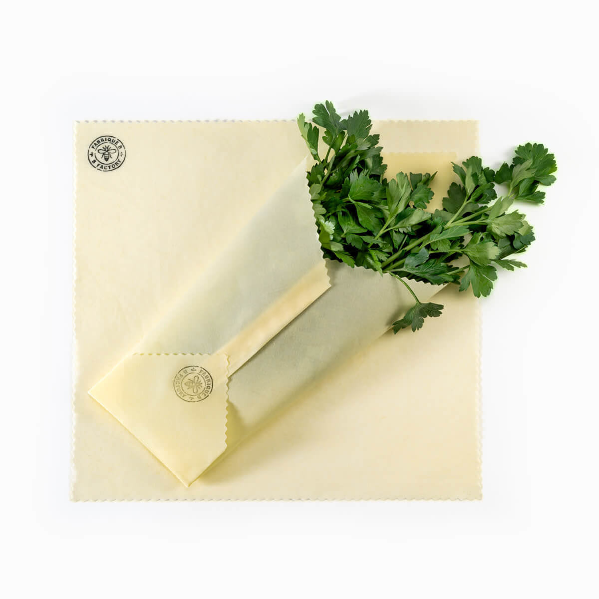 Italian parsley wrapped in eco-friendly beeswax food wrap on top of small reusable beeswax wrap with B Factory logo