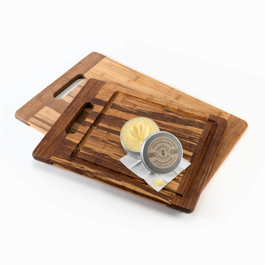 Open tin of B Factory beeswax wood butter on top of 2 wood cutting boards