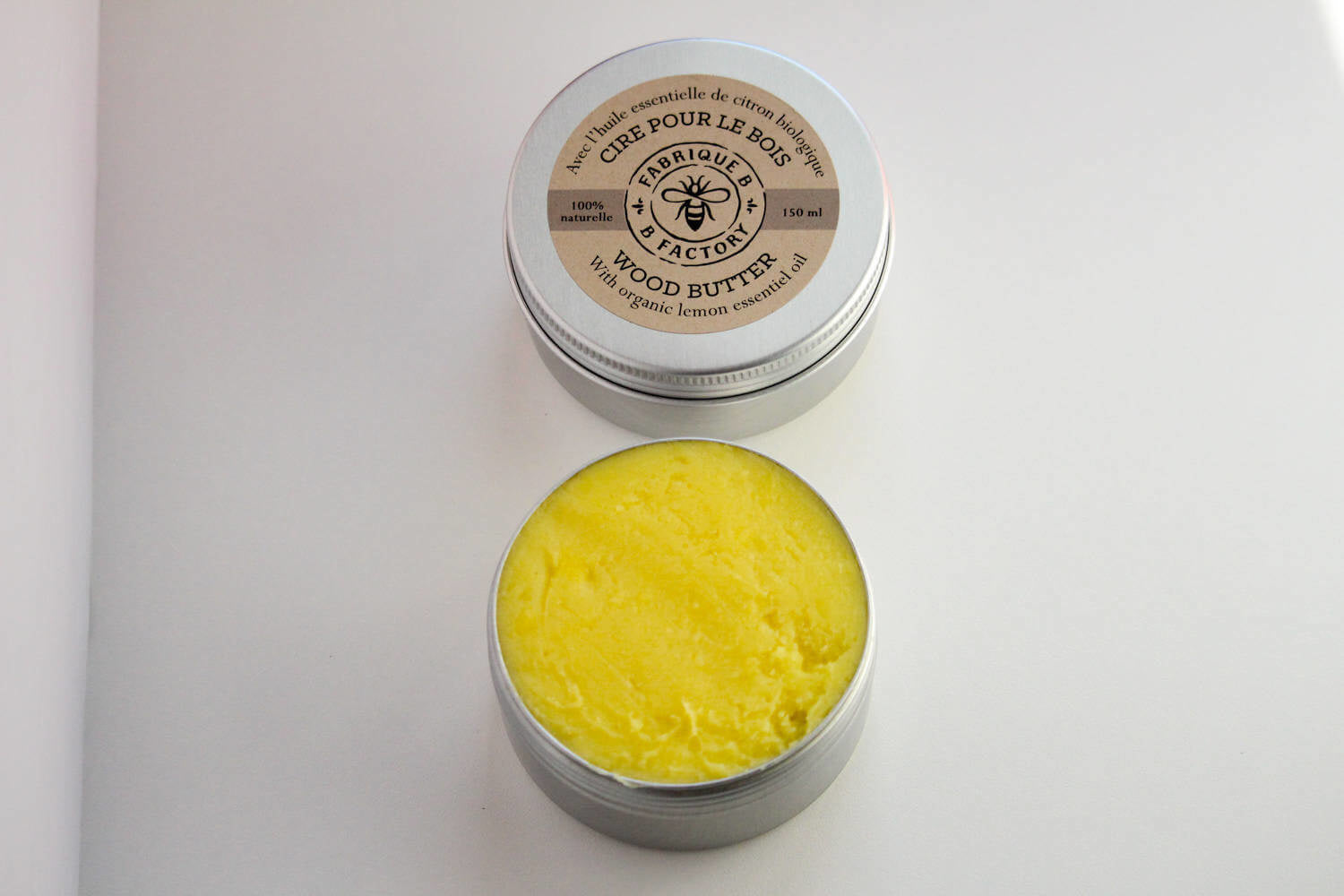 Natural beeswax wood butter in open silver tin with B Factory logo on lid