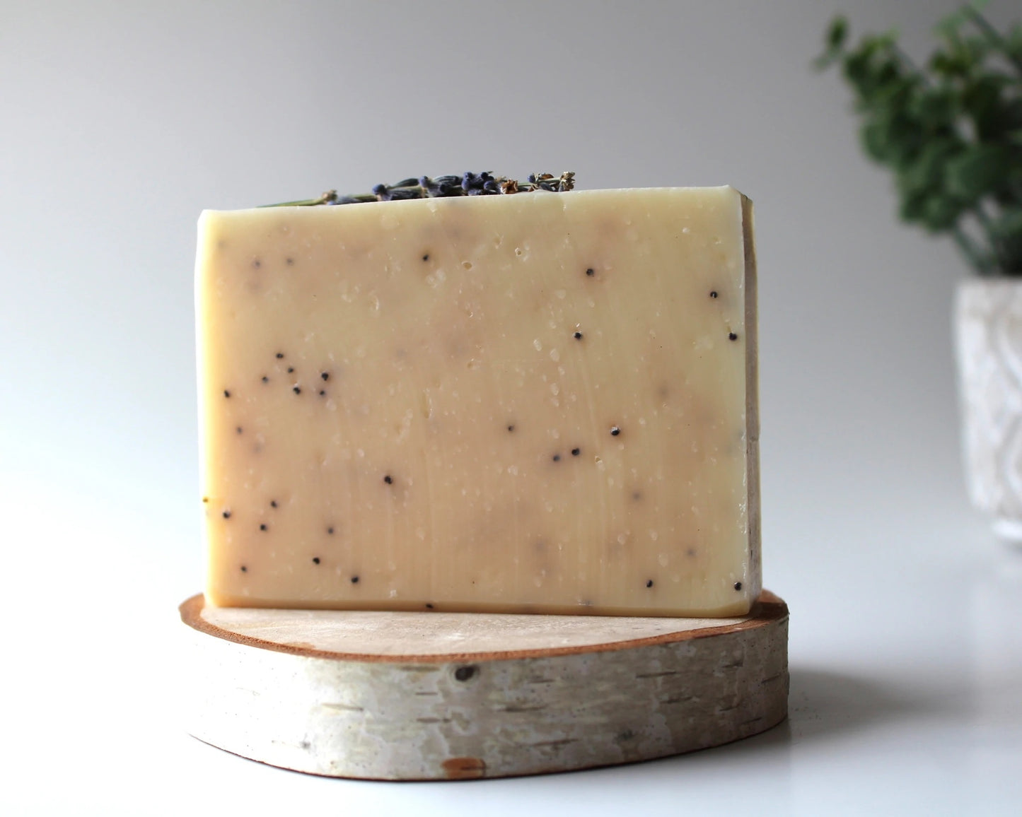 Handmade natural exfoliant soap bar on wood platform