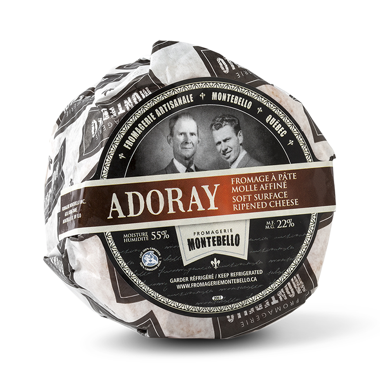 A wheel of Fromagerie Montebello Adoray cheese, featuring a soft, creamy interior with a delicate rind in branded packaging.
