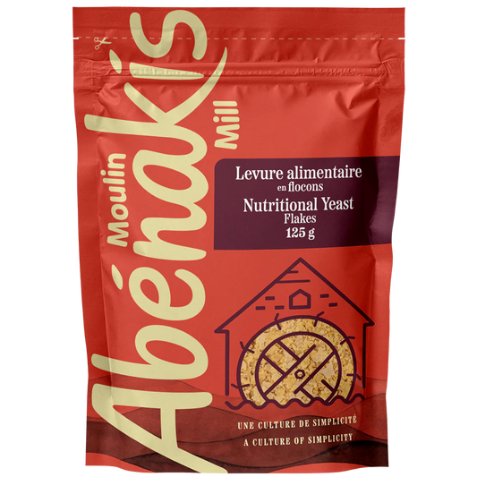 A bag of ABÉNAKIS grilled nutritional yeast flakes, featuring golden flakes used as a savory, cheesy-flavored seasoning.