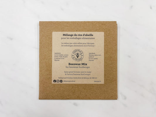 Square cardboard envelope with B Factory Beeswax Mix on a white marble surface
