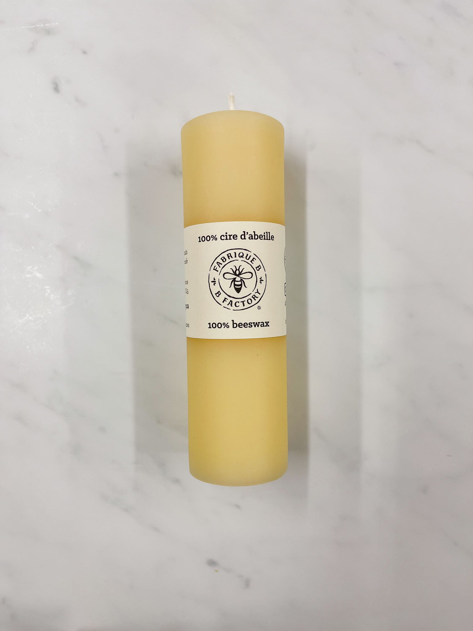 Slim pure beeswax pillar candle with B Factory logo