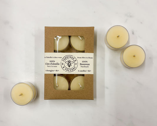 3 white beeswax tea light candles next to set of 6 white beeswax tea light candles in gift box with B Factory logo on lid