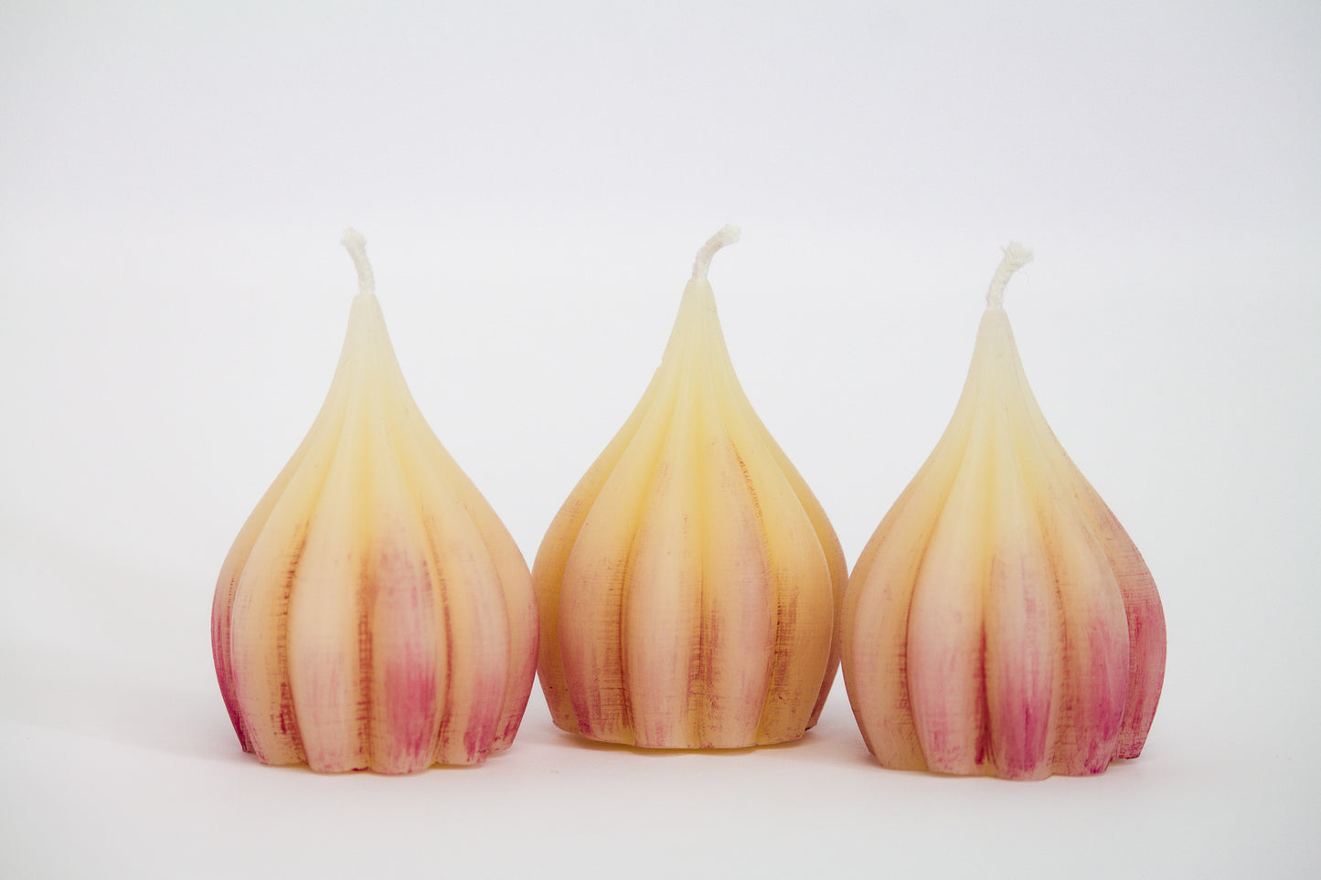 3 large garlic-shaped pure beeswax candles with some purple tint to resemble real garlic