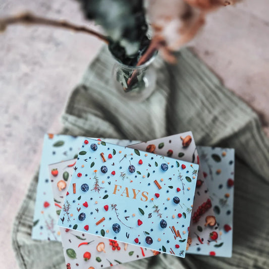 Stack of box of artisanal chocolates with 'FAYS' design on a textured surface