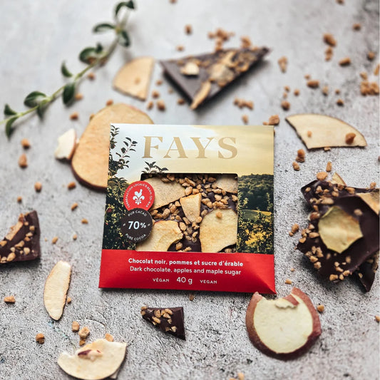 Fays chocolate bar packaging with dark chocolate pieces and maple sugar and apple slices on a gray surface