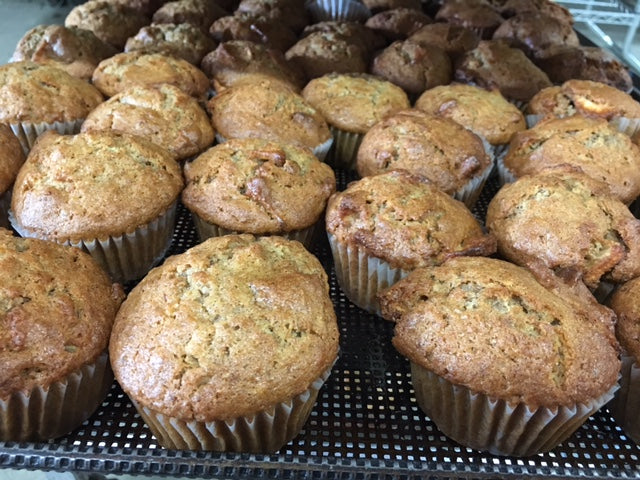 A bunch of Quinn Farms apple muffins, featuring a soft, moist texture with visible apple pieces in a bakery-style presentation.