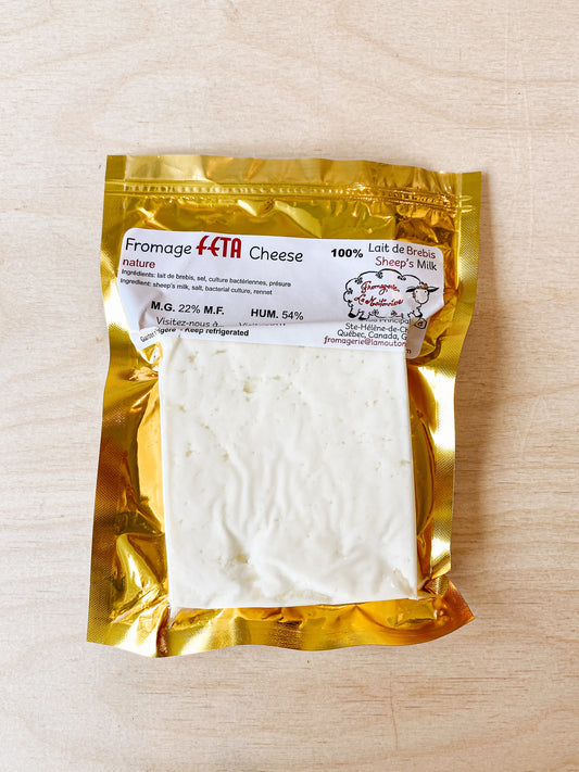 Gold packaging feta nature cheese by La Moutonnière on a wooden surface