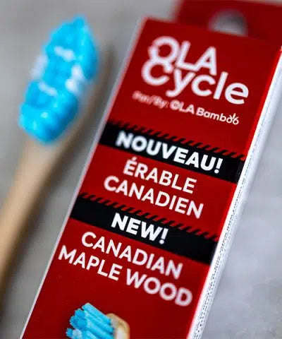 close-up of "Ola cycle Canadian Maplewood" toothbrush box, with head of toothbrush blurred to left of box