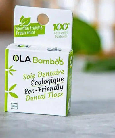 box of eco-friendly dental floss by Ola Bamboo set on a pale grey surface