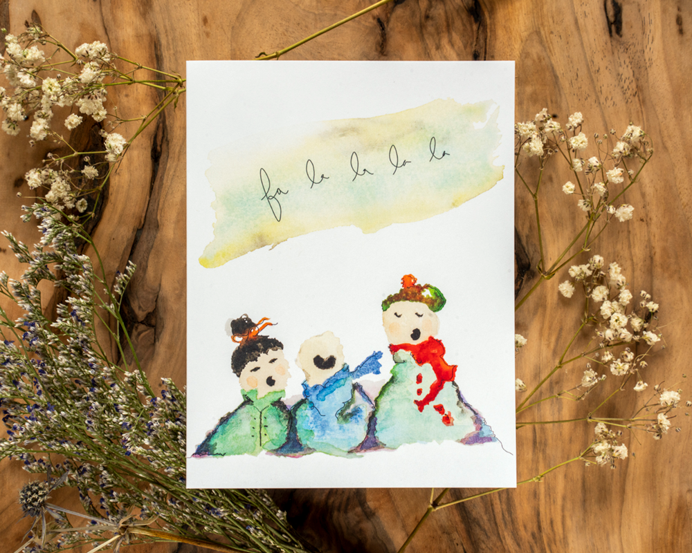 Watercolor illustration of three children on a card with decorative elements on a wooden background
