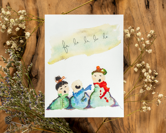 Watercolor illustration of three children on a card with decorative elements on a wooden background