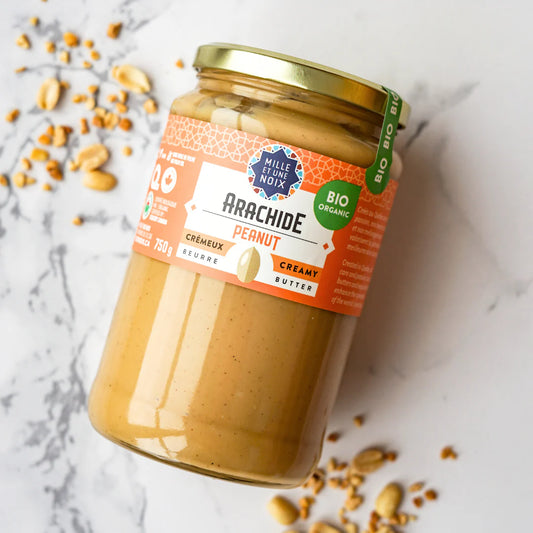 A jar of Mille et Une Noix organic creamy peanut butter (750g), featuring a smooth, rich peanut spread in large-format packaging.