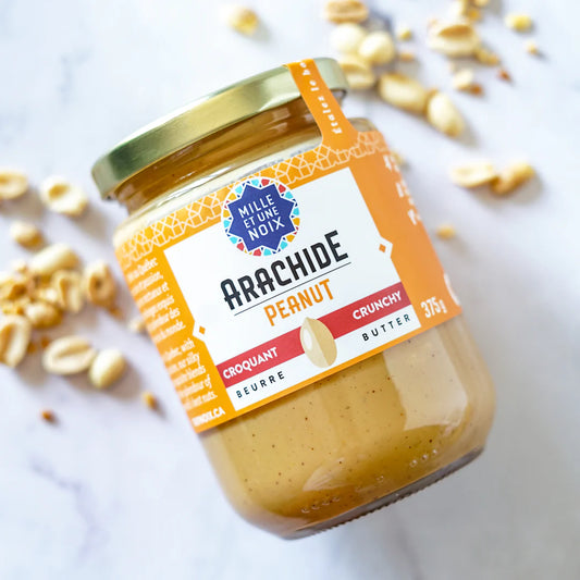 Jar of crunchy organic peanut butter by Mille Et Une Noix
