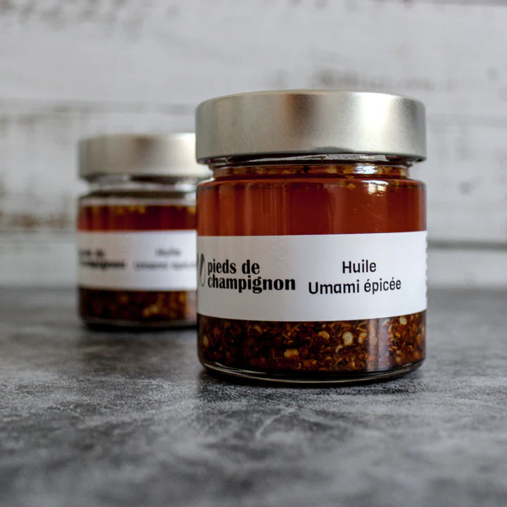 A jar of Les 400 Pieds de Champignon spicy umami oil, featuring a rich chili-infused oil with mushroom-based flavor in branded packaging.