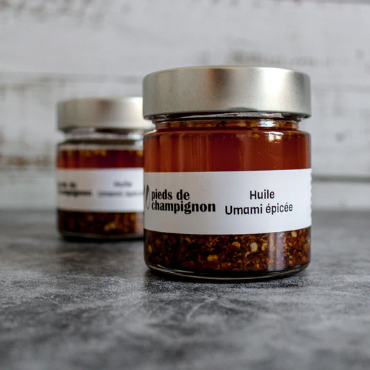 A jar of Les 400 Pieds de Champignon spicy umami oil, featuring a rich chili-infused oil with mushroom-based flavor in branded packaging.