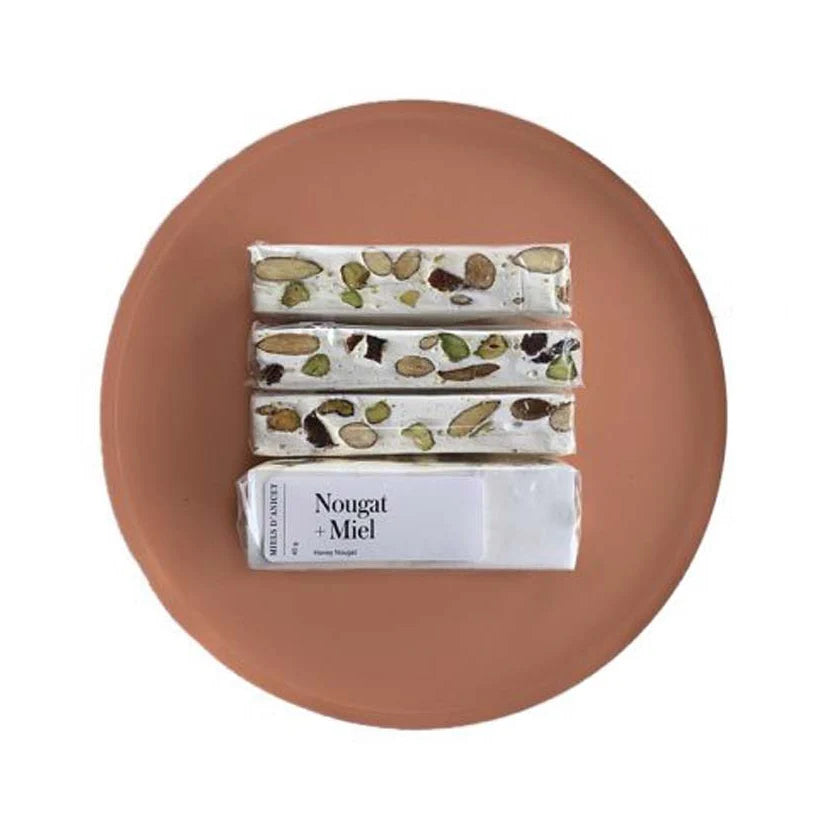 A package of Miels d’Anicet nougat with honey, featuring a soft, chewy confection with visible nuts in branded packaging.