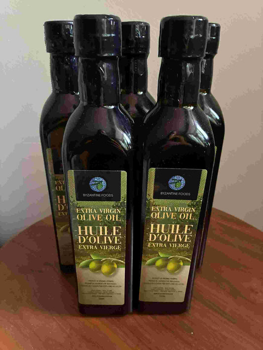Bottles of olive oil with labels on a wooden surface