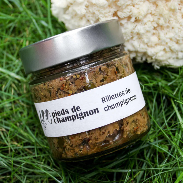 A jar of Les 400 Pieds de Champignon mushroom rillettes, featuring a savory spread made from finely prepared mushrooms in branded packaging.