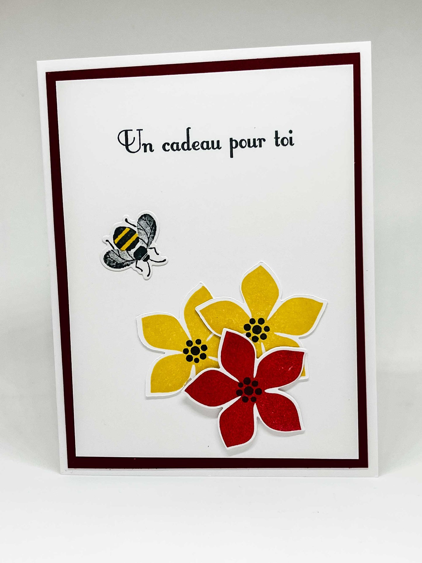 Pop-up greeting card with honeybee, yellow and red flowers, and text that says a gift for you in French