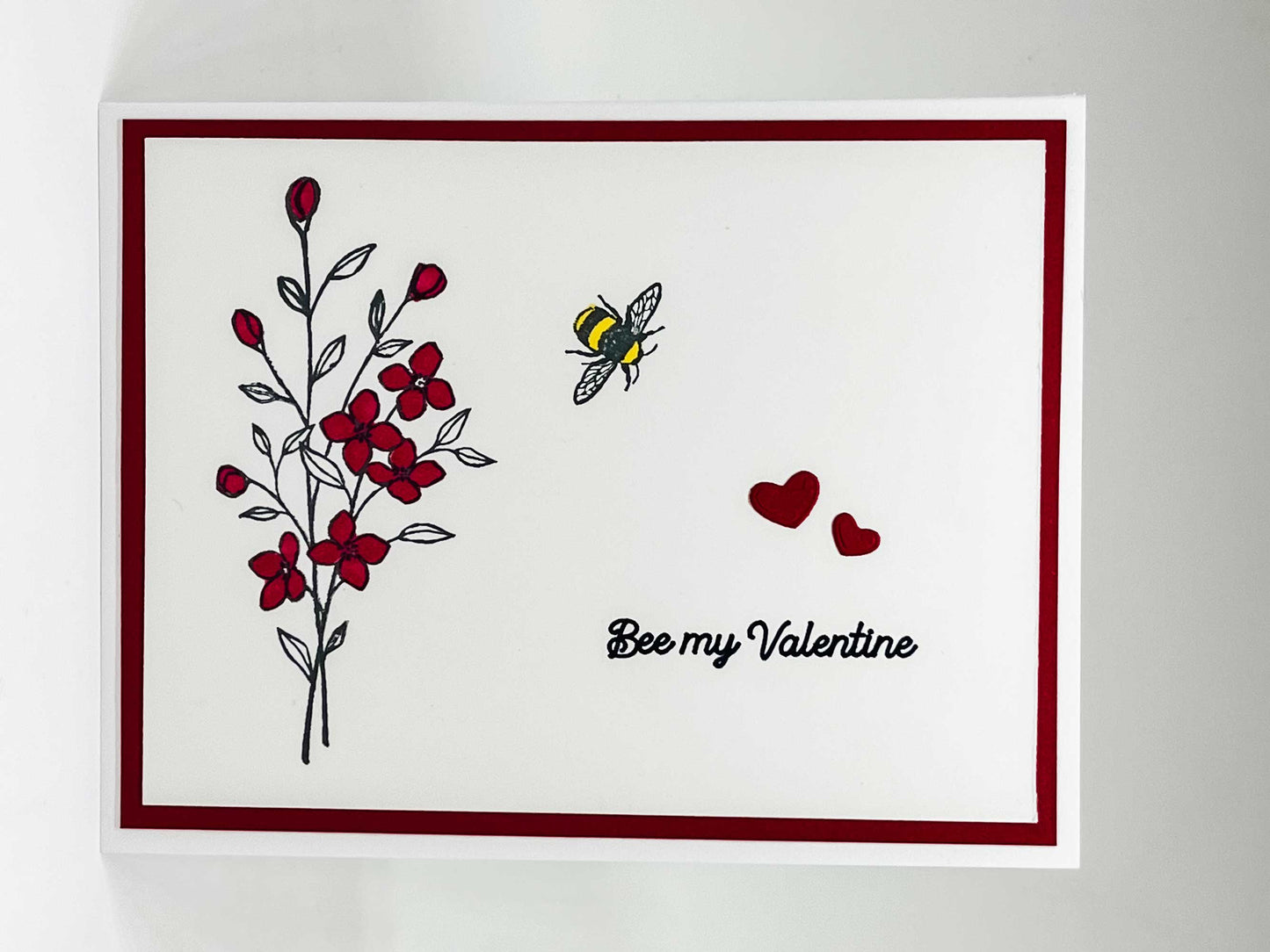 Valentine's Day card with honeybee, red flowers and text that says bee my Valentine