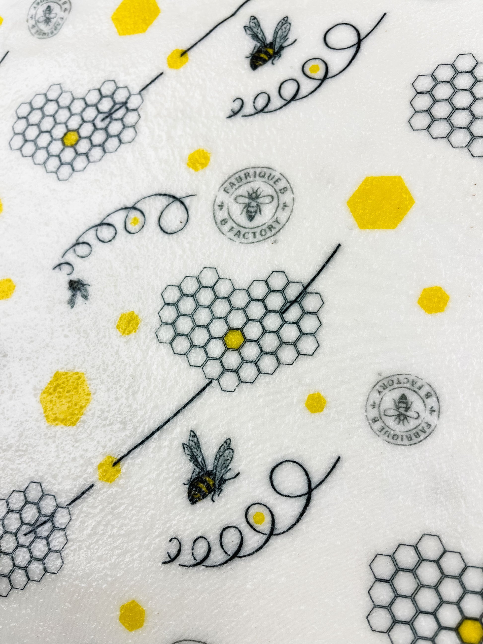 Close up of eco-friendly beeswax wrap with honeycombs, bees, and B Factory logo