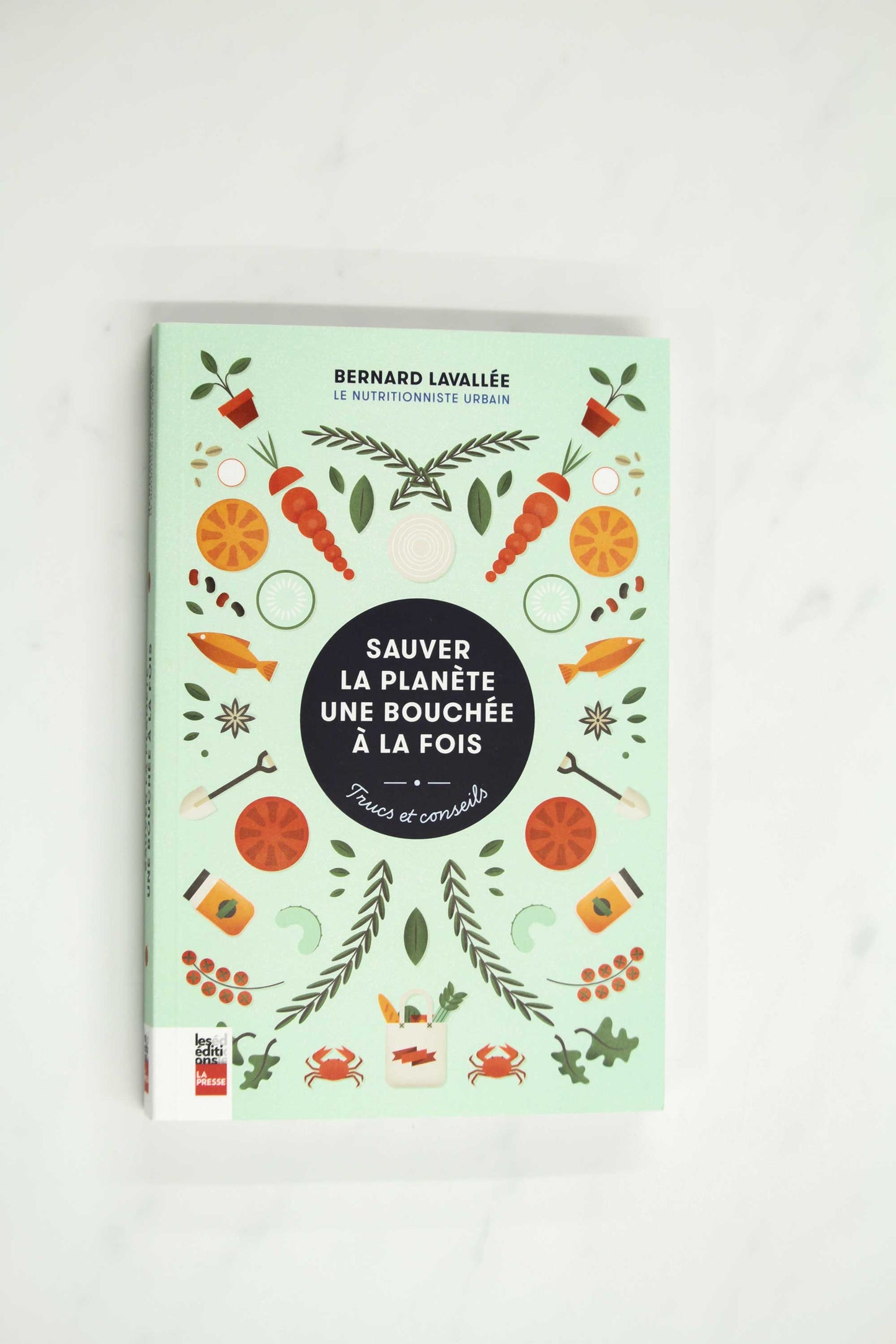 Sauver la planète une bouchée à la fois green book cover with illustration of carrots, fish, tomatoes, and herbs