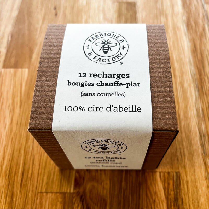 Boîte en carton qui dit 12 recharges bougies chauffe-plat sans coupelles, 100% cire d'abeille par B Factory 