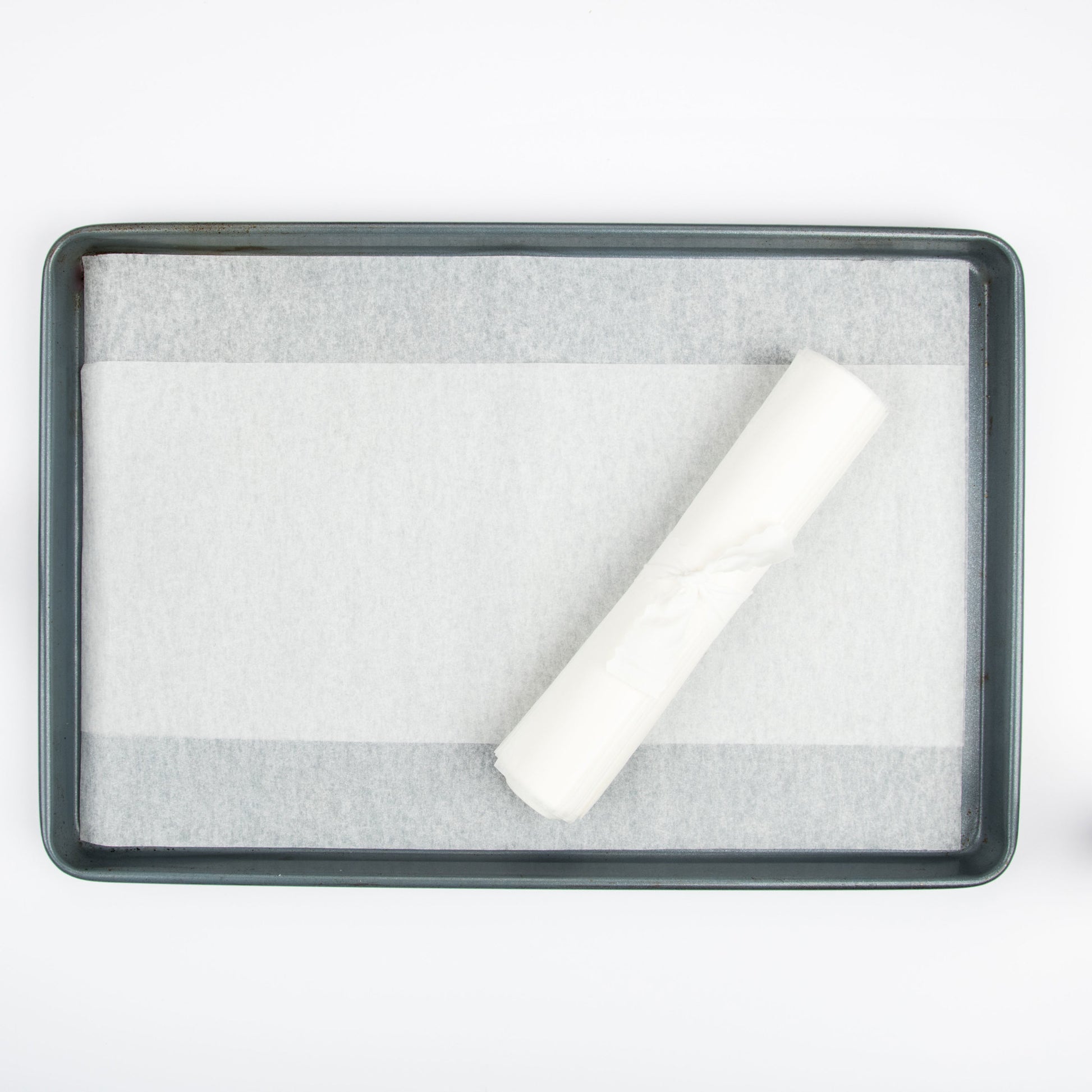 Parchment paper roll on top of parchment paper-lined baking tray